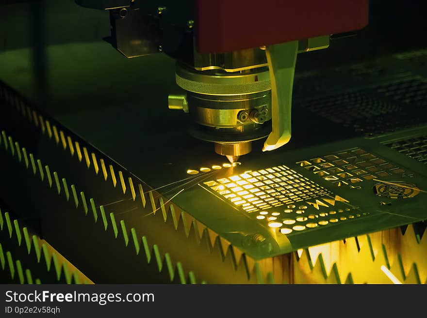 The CNC fiber laser cutting machine cutting the metal plate with the sparking light. The sheet metal working operation. The CNC fiber laser cutting machine cutting the metal plate with the sparking light. The sheet metal working operation