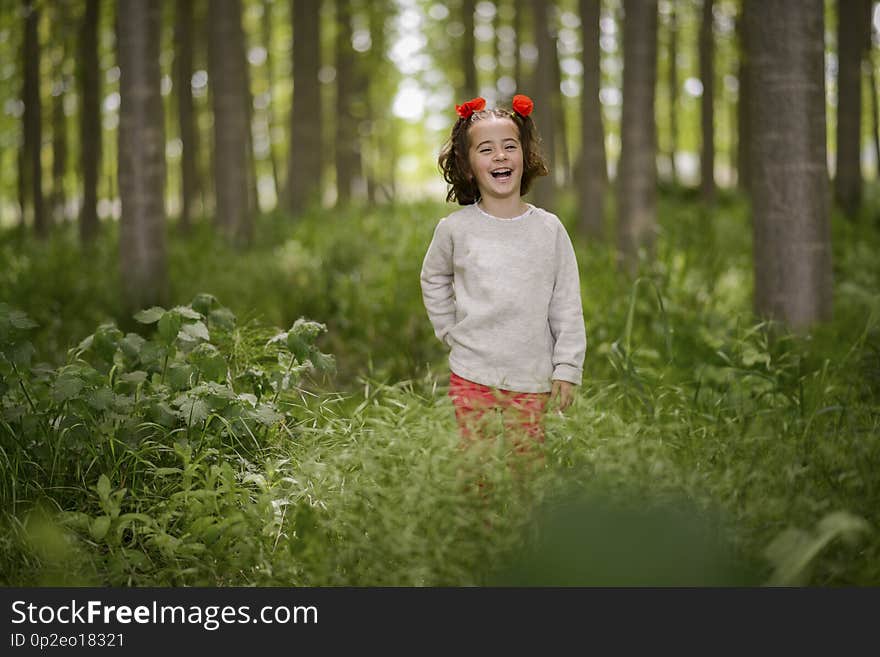 Cute little girl having fun in a poplar forest