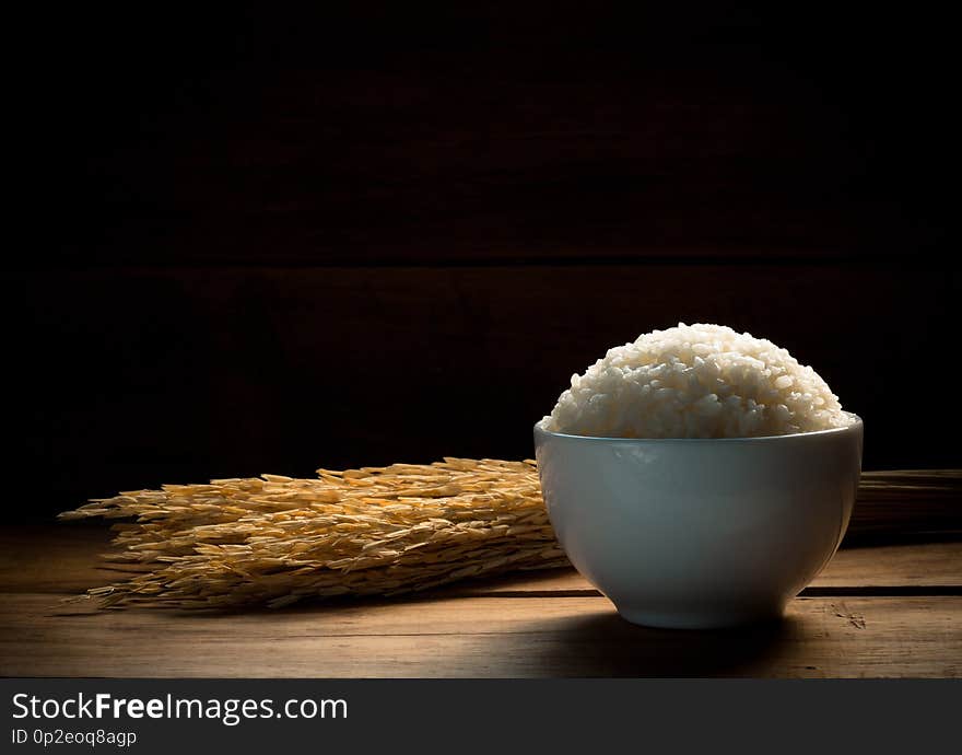 Steam White rice in white ceramic bowl on wood table for healthy meal. Cook concept. Selective focus