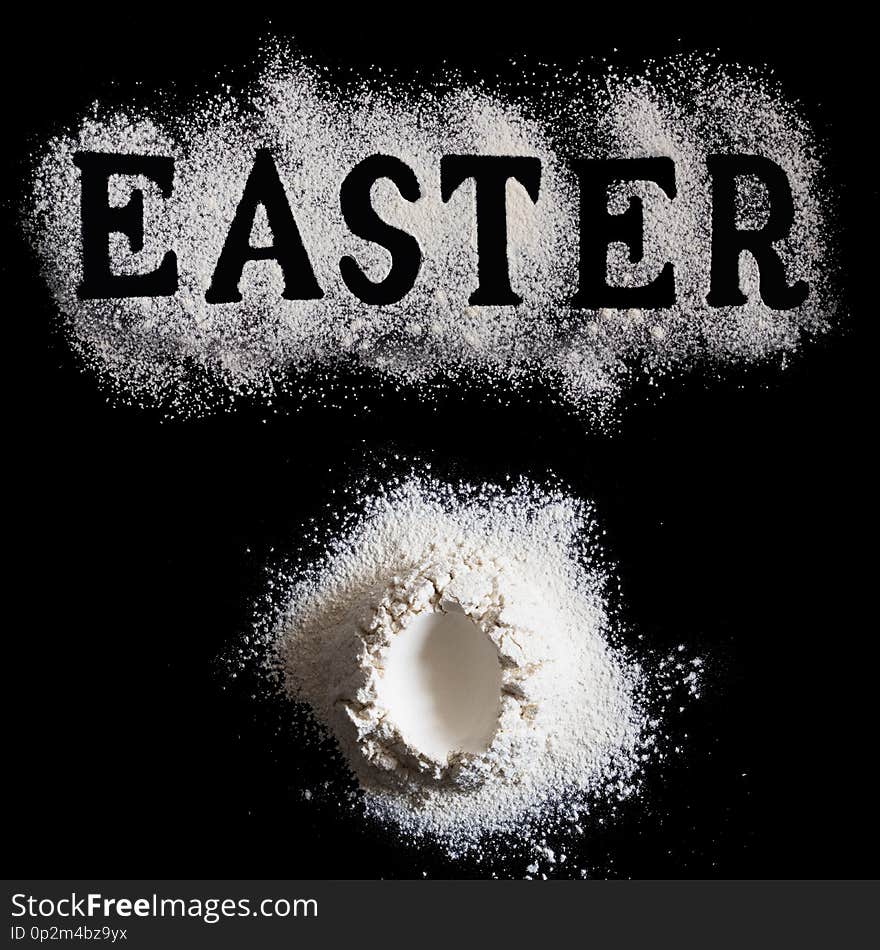 Letters EASTER made with sieved flour and Handrful of flour with with egg shape hole in the center on black background, Easter baking concept, Monochrome, Holiday