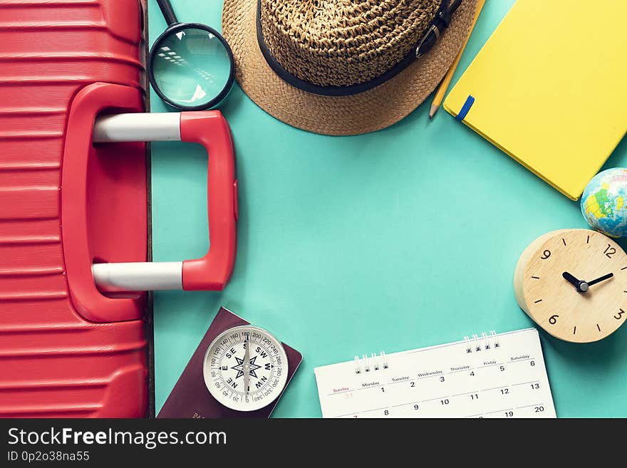 Concept of travel vacation trip and long weekend suitcase or luggage, passport, clock and calendar planning on green background. Concept of travel vacation trip and long weekend suitcase or luggage, passport, clock and calendar planning on green background