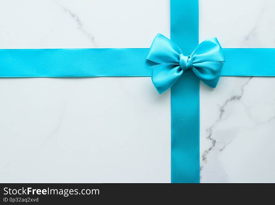 Blue silk ribbon on marble, top view