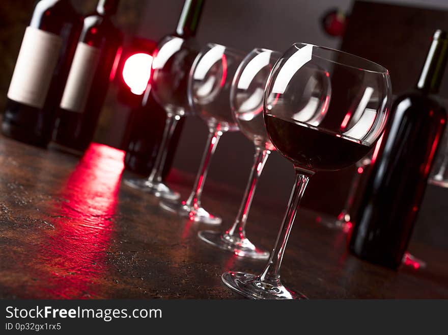 Glasses and bottles of red wine on a table in bar. Selective focus