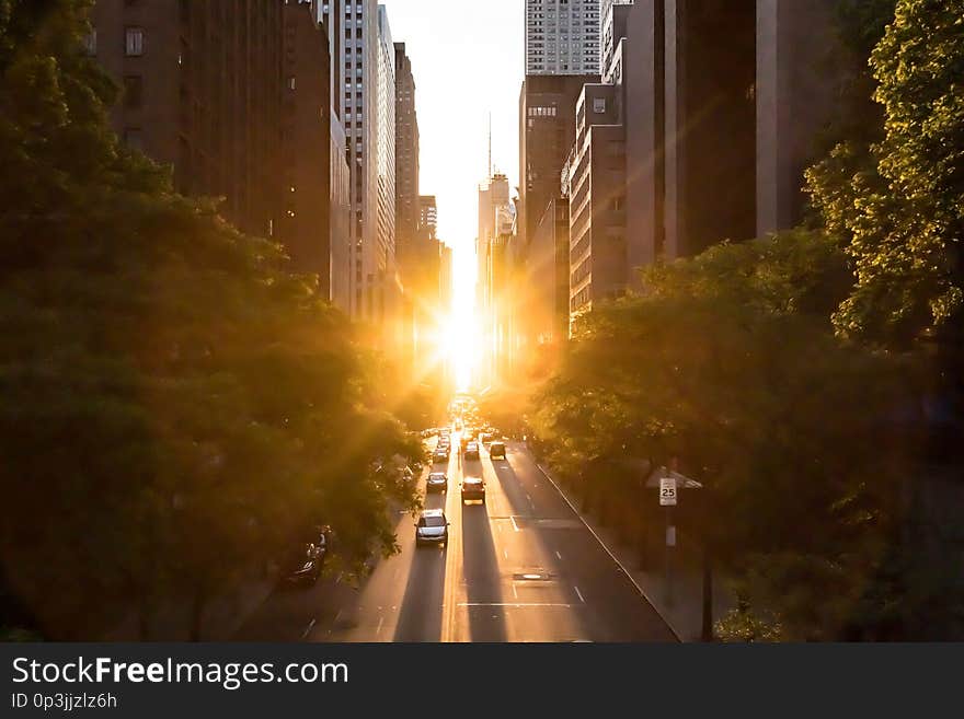 Sunlight shines on the buildings and cars along 42nd Street through Midtown Manhattan around the Manhattanhenge sunset in New York City. Sunlight shines on the buildings and cars along 42nd Street through Midtown Manhattan around the Manhattanhenge sunset in New York City