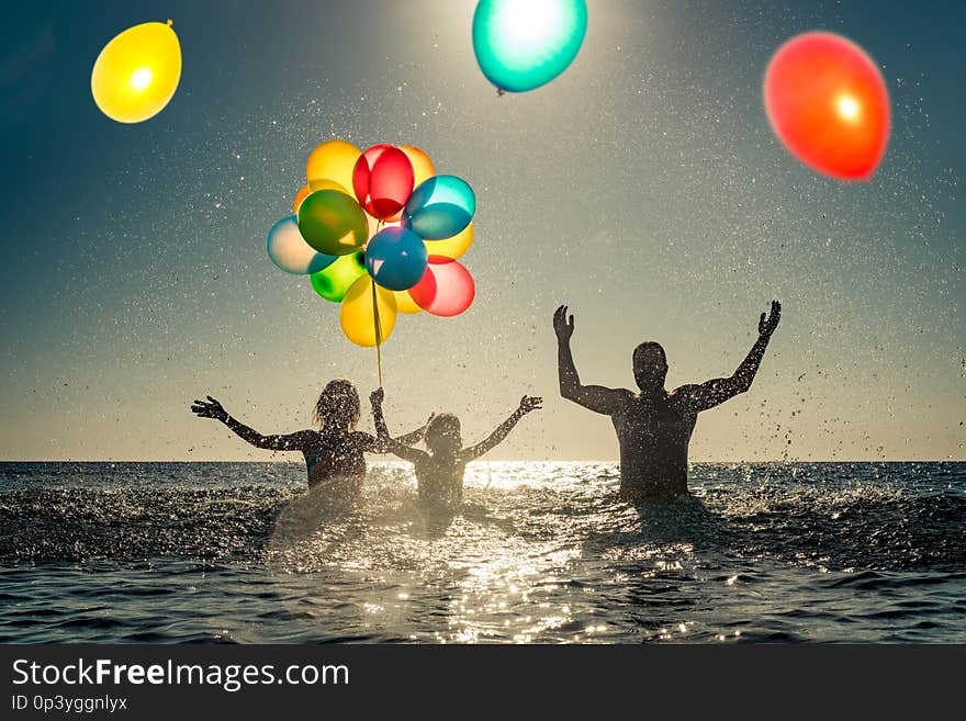 Happy family playing in the sea. Child, mother and father having fun on summer vacation. Healthy active lifestyle concept. Happy family playing in the sea. Child, mother and father having fun on summer vacation. Healthy active lifestyle concept