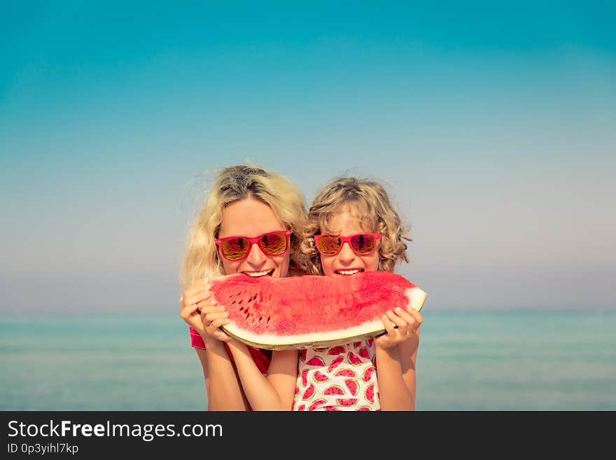 Happy family on summer vacation. People eating watermelon on the beach. Healthy lifestyle concept. Happy family on summer vacation. People eating watermelon on the beach. Healthy lifestyle concept