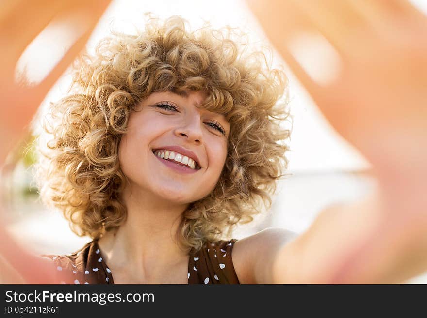 Portrait of young woman with curly hair outdoors