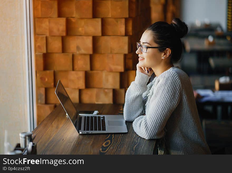 Girl working on a laptop at a restaurant