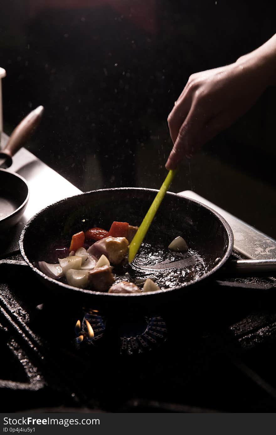 Chef In Restaurant Kitchen Preparing Food dark background