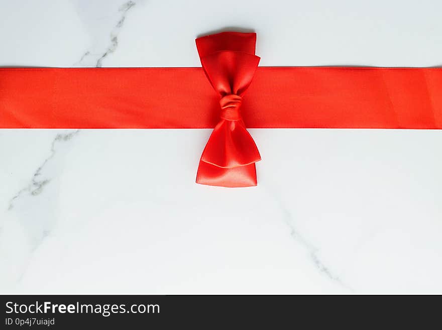 Holiday decor, feminine design and flatlay concept - Red silk ribbon on marble, top view