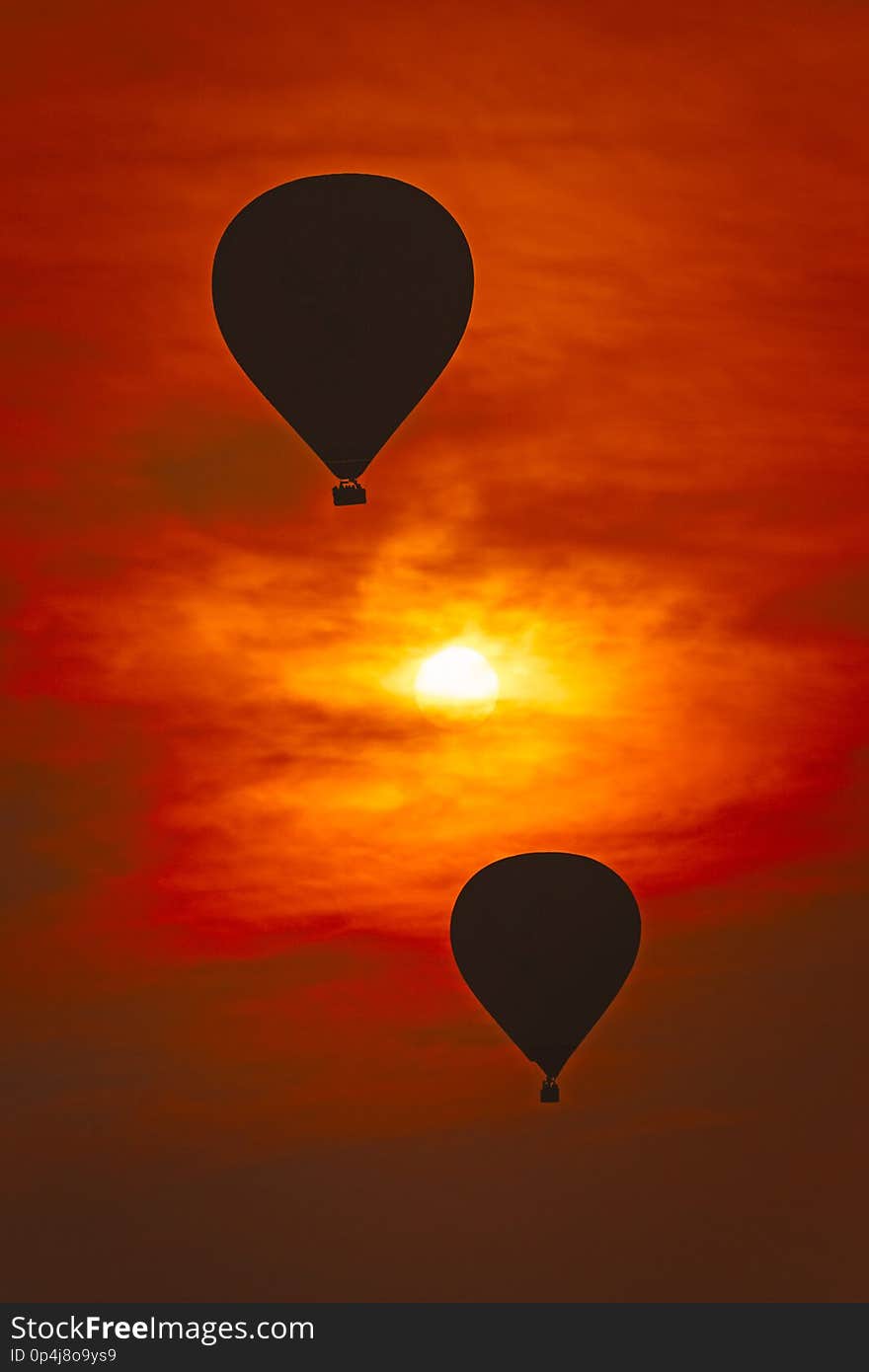 2 air balloons against red sky and the sun is in between. 2 air balloons against red sky and the sun is in between.