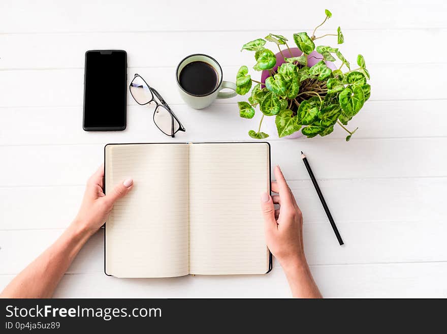 Top view of girl holding notebook with background composition on white table. Top view of girl holding notebook with background composition on white table