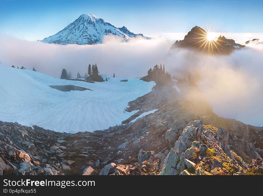 Morning light high above the cloud layer on Mount Rainier. Beautiful Paradise area, Washington state, USA.