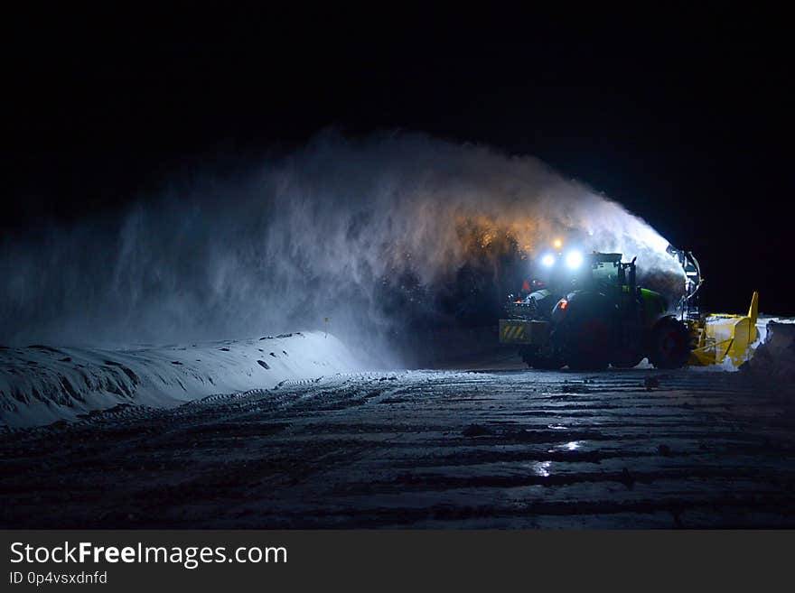 Snow-blower removing snow in the evening on a country road in winter in Canada