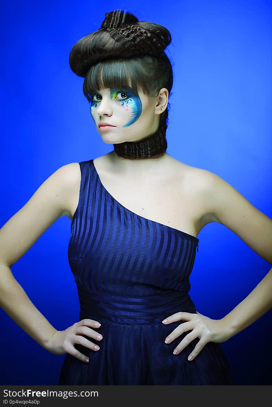 Bright brunette with creative make up in blue dress