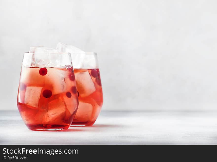 Cranberry cocktail cape kodder with ice, rosemary and berries, bar tools, blue bar counter background, top view