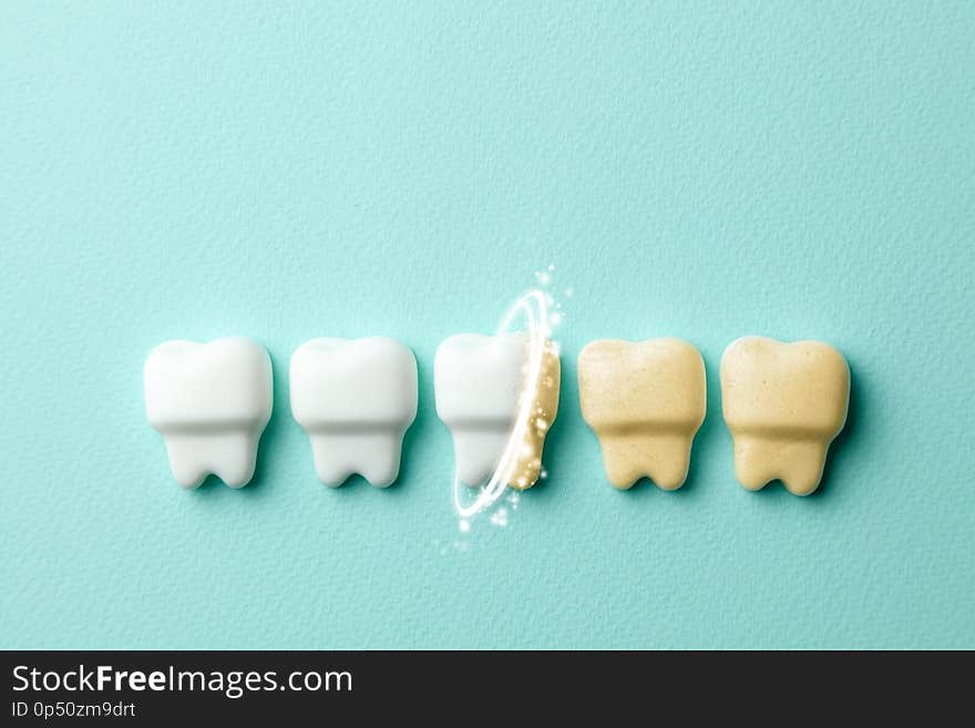 Teeth whitening. Healthy white teeth and yellow from cigarettes and coffee on green mint background.