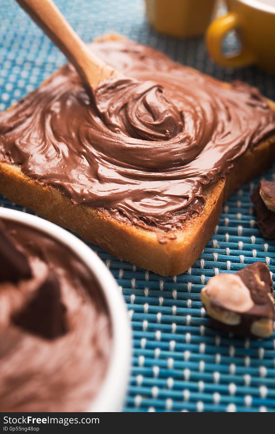 Sweet breakfast of bread with chocolate spread and a cup of coffee on the morning table