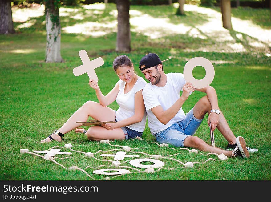 Laughing boy and girl playing tic-tac-toe in the park.