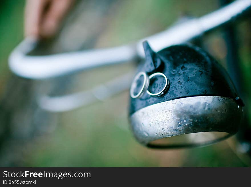 Two wedding rings on the light of vintage bicycle. Rainy wedding day. Focus on the ring with diamond