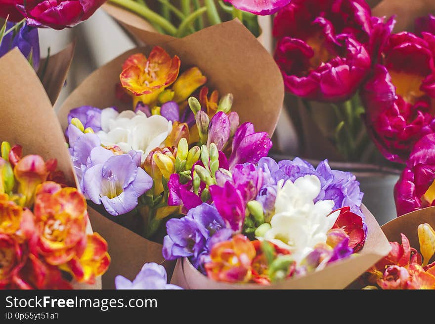 Bouquet of colorful fresh freesia in a craft paper