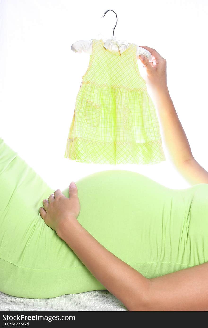 A Happy pregnant girl lies on white background