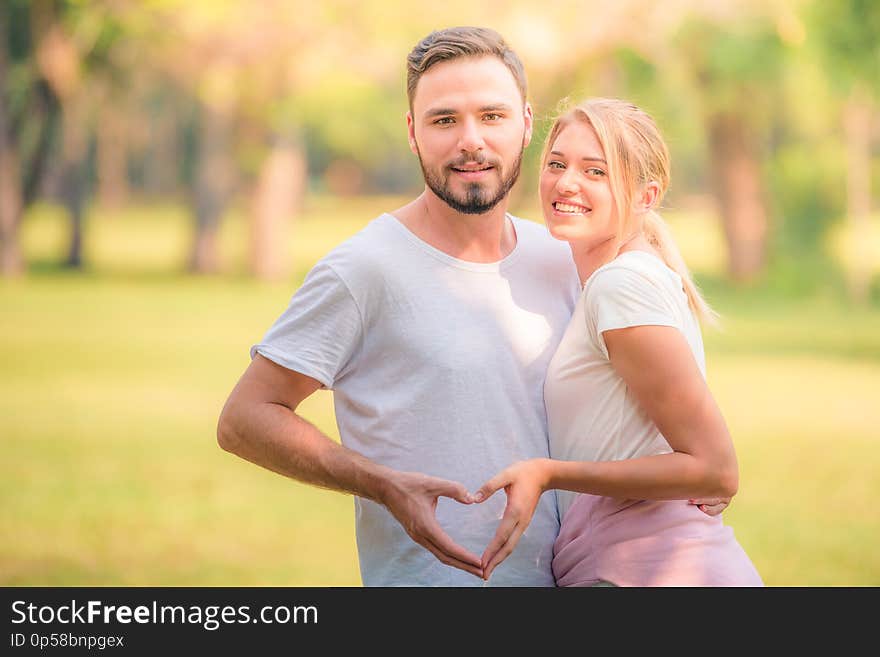 Portrait of Young couple enjoying in the park at sunset. Concept romantic and love. Warm tone