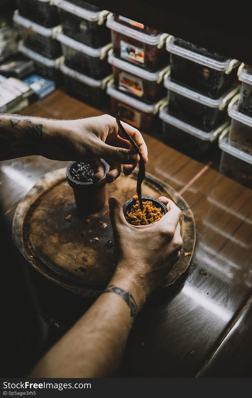 Closeup of the hand of a man who runs tobacco jam into a hookah. Closeup of the hand of a man who runs tobacco jam into a hookah.