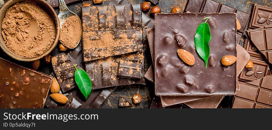 Chocolate pieces with leaves. On a wooden background