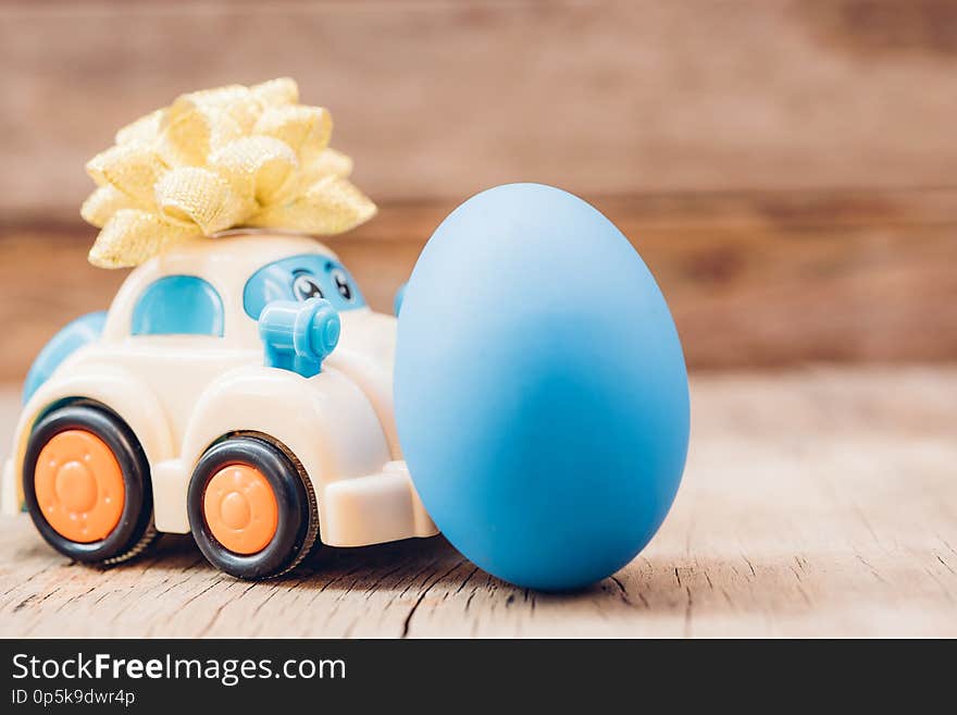 Easter egg and toy car on wooden background