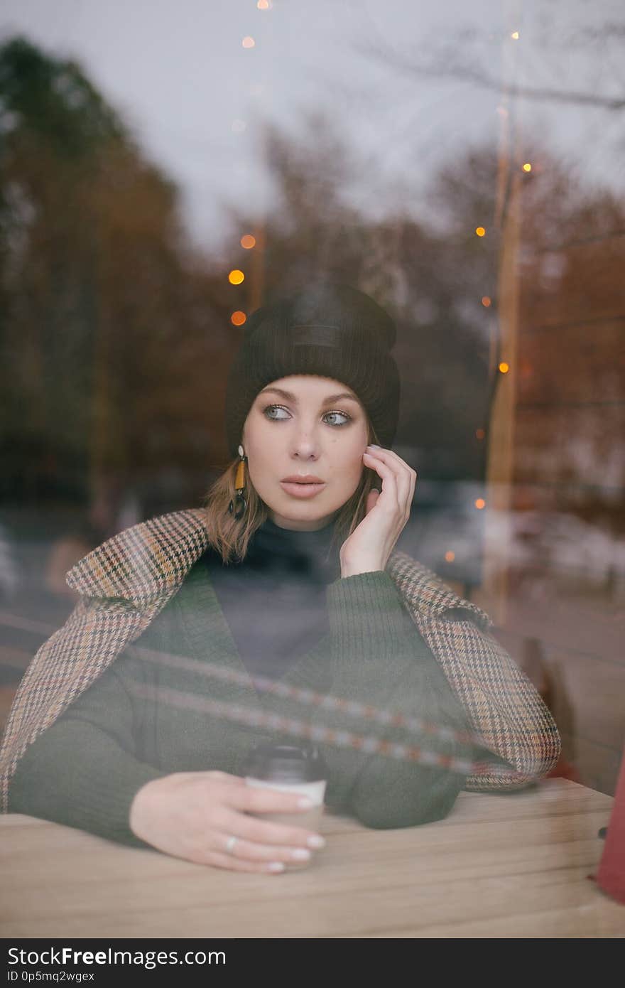 Young beautiful woman wearing fashion clothes sitting in a cafe