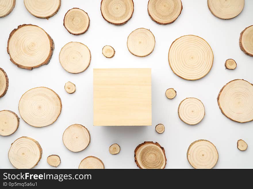 Pine tree cross-sections with annual rings and wooden square on white background. Lumber piece close-up, top view.