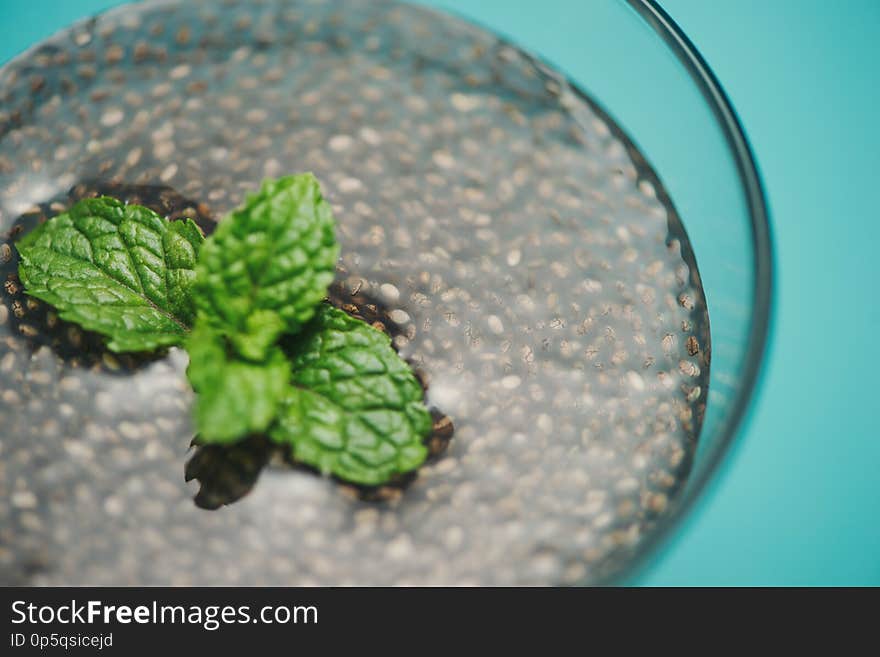 Glass of water with cup of healthy chia seeds and spoon. Text space.