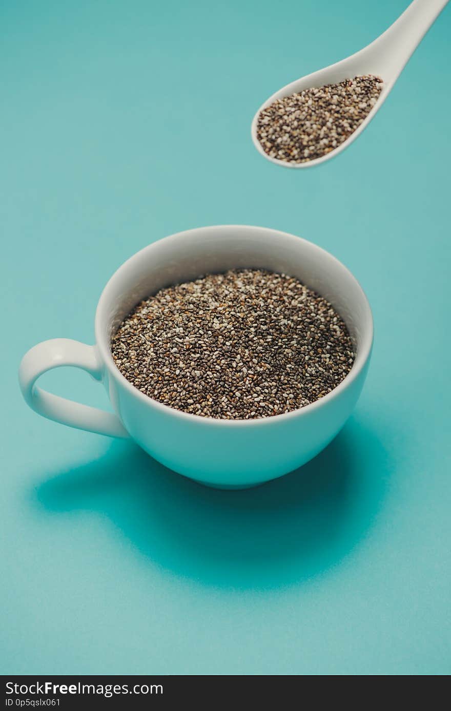 Cup of healthy chia seeds and spoon. Text space.