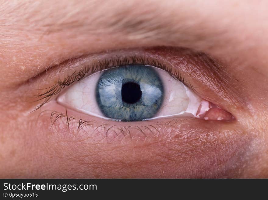 Attentive penetrating male beautiful blue gaze. The man`s eyes closeup. Attentive penetrating male beautiful blue gaze. The man`s eyes closeup