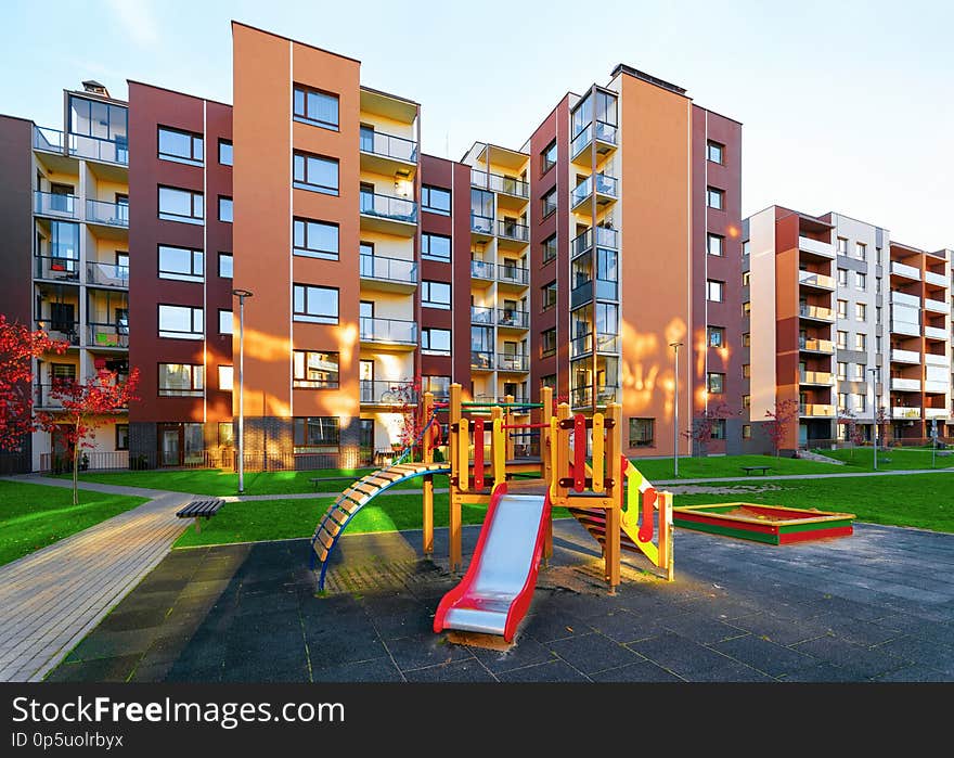 Apartment residential house facade architecture and kid playground and outdoor facilities. Blue sky on the background