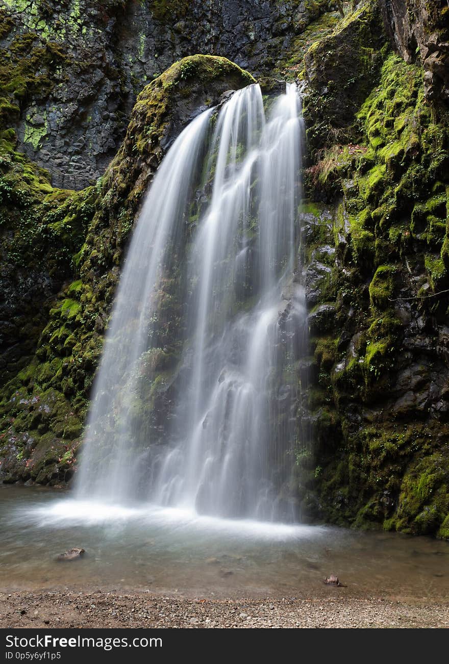 Waterfall surrounded by green mossy rocks in the forest. Waterfall surrounded by green mossy rocks in the forest.