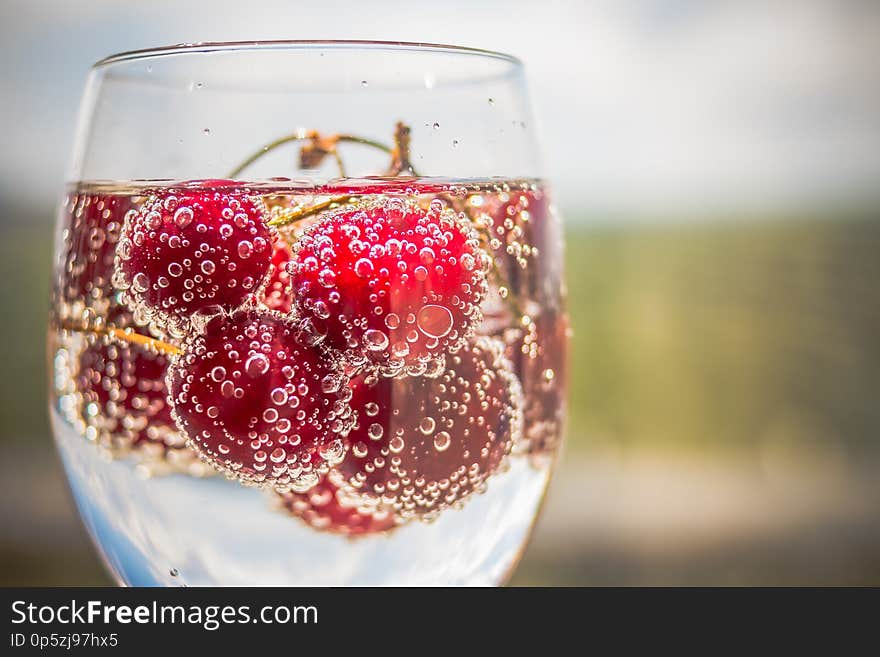 Summer iced refreshment drink, cherry cola lemonade or mojito cocktail in tall glass, on light blue and grey background