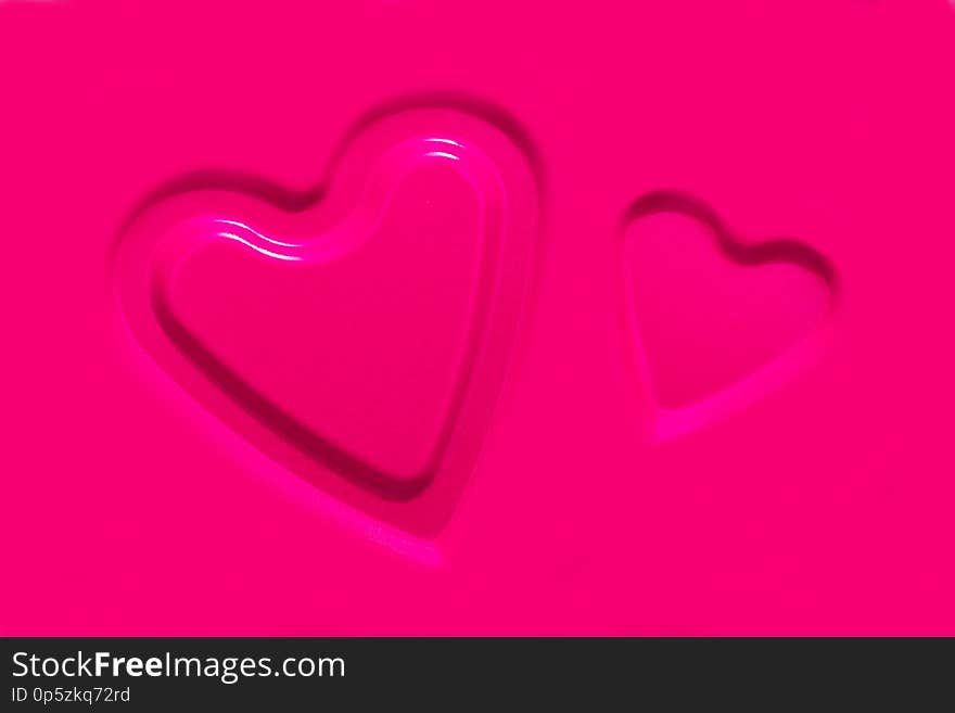 Two convex contours of hearts on a pink metallic background. A blank for a holiday card about love for Valentine`s