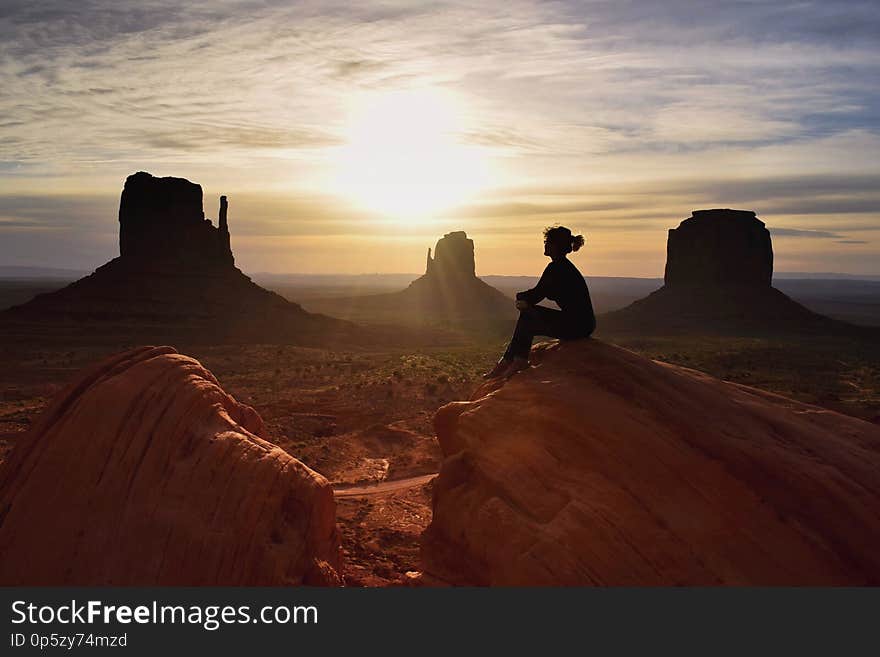 Woman hiker watching beautiful scenery of sunrise in Monument valley, Navajo tribal park , Utah, USA. Woman hiker watching beautiful scenery of sunrise in Monument valley, Navajo tribal park , Utah, USA