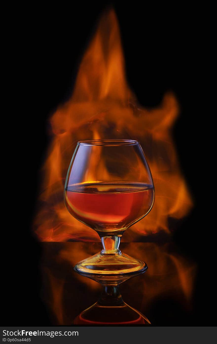 Burning alcoholic drinks with ice cubes, on black background