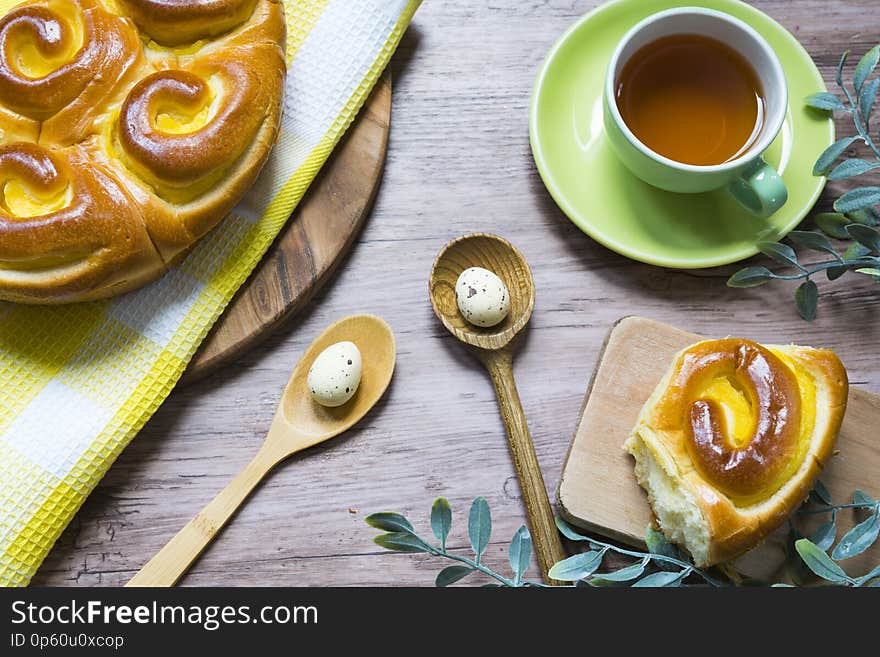 Wooden table with cup of tea, cutting board with Easter Chinois bread and eggs. Wooden table with cup of tea, cutting board with Easter Chinois bread and eggs.