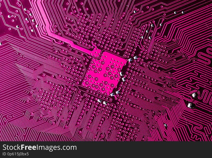 Close up photo of pink printecd circuit board with solder points. Close up photo of pink printecd circuit board with solder points