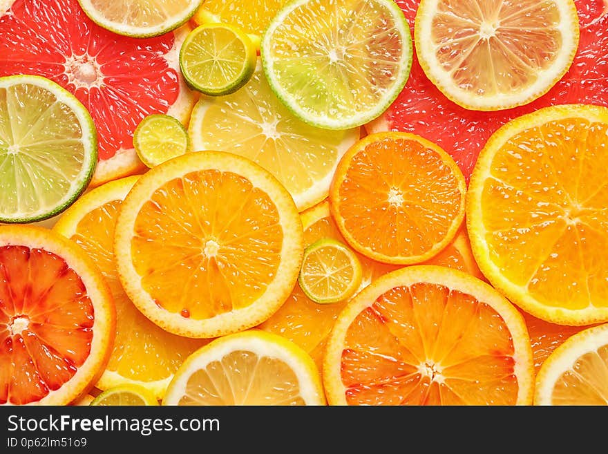 Slices of fresh citrus fruits as background, top view