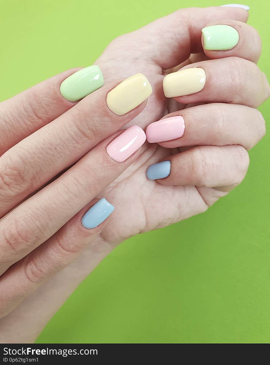 Female hands manicure on color paper minimal