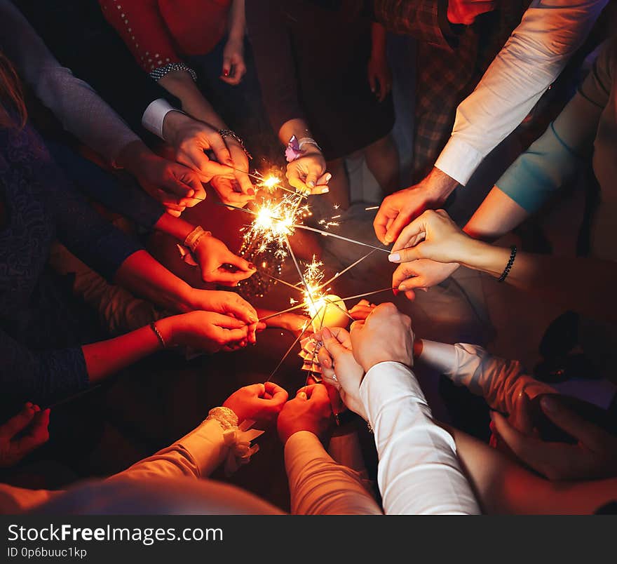 People set fire to sparklers. only hand. People set fire to sparklers. only hand