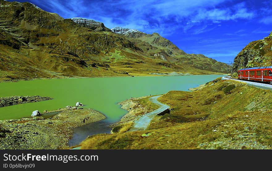 The Bernina Express is an express train connecting Chur &#x28;or Davos&#x29; in Switzerland with Poschiavo and Tirano in Italy, by crossing the Swiss Alps from north to south. For most of its journey, the train also passes along and through the World Heritage Site known as the Rhaetian Railway in the Albula / Bernina Landscapes. The train is operated by the Rhaetian Railway company. It is not an &quot;express&quot; in the sense of being a high-speed train, but, rather, in the sense that it provides a one-seat ride for a long duration trip. The Bernina Express itself is composed of panoramic coaches with a piped multi-lingual commentary, and a small supplement and seat reservation are both obligatory. The train is popular with tourists, and connects in Tirano with the Post Bus service via Lake Como in Italy to Lugano in Switzerland. The Albula line and the Bernina line on the Bernina Express route were jointly declared a World Heritage Site in 2008. The trip on the Bernina Express through this World Heritage Site is a 4 hour railway journey across 196 bridges, through 55 tunnels and across the Bernina Pass on the highest point at 2,253 metres in altitude. The entire line is 1,000 mm &#x28;3 ft 3 3⁄8 in&#x29; &#x28;metre gauge&#x29;. The Albula line was constructed between 1898 and 1904, and has been operated by the Rhaetian Railway ever since. The Bernina Railway built the Bernina line between 1908-1910, and then operated it independently until the 1940s, when the Rhaetian Railway took it over. The Bernina Express uses gradients of 7% to achieve a difference in height of about 1800 meters from the summit at Ospizio Bernina to Tirano. SWITZERLAND AUTUMN 2012 See where this picture was taken. [?]. The Bernina Express is an express train connecting Chur &#x28;or Davos&#x29; in Switzerland with Poschiavo and Tirano in Italy, by crossing the Swiss Alps from north to south. For most of its journey, the train also passes along and through the World Heritage Site known as the Rhaetian Railway in the Albula / Bernina Landscapes. The train is operated by the Rhaetian Railway company. It is not an &quot;express&quot; in the sense of being a high-speed train, but, rather, in the sense that it provides a one-seat ride for a long duration trip. The Bernina Express itself is composed of panoramic coaches with a piped multi-lingual commentary, and a small supplement and seat reservation are both obligatory. The train is popular with tourists, and connects in Tirano with the Post Bus service via Lake Como in Italy to Lugano in Switzerland. The Albula line and the Bernina line on the Bernina Express route were jointly declared a World Heritage Site in 2008. The trip on the Bernina Express through this World Heritage Site is a 4 hour railway journey across 196 bridges, through 55 tunnels and across the Bernina Pass on the highest point at 2,253 metres in altitude. The entire line is 1,000 mm &#x28;3 ft 3 3⁄8 in&#x29; &#x28;metre gauge&#x29;. The Albula line was constructed between 1898 and 1904, and has been operated by the Rhaetian Railway ever since. The Bernina Railway built the Bernina line between 1908-1910, and then operated it independently until the 1940s, when the Rhaetian Railway took it over. The Bernina Express uses gradients of 7% to achieve a difference in height of about 1800 meters from the summit at Ospizio Bernina to Tirano. SWITZERLAND AUTUMN 2012 See where this picture was taken. [?]