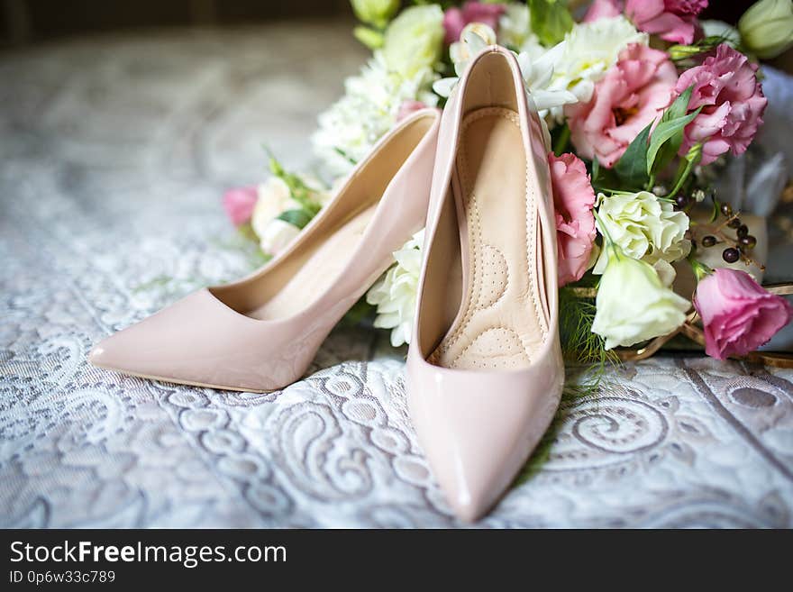 Wedding elegant shoes with bouquet on bed. Wedding elegant shoes with bouquet on bed