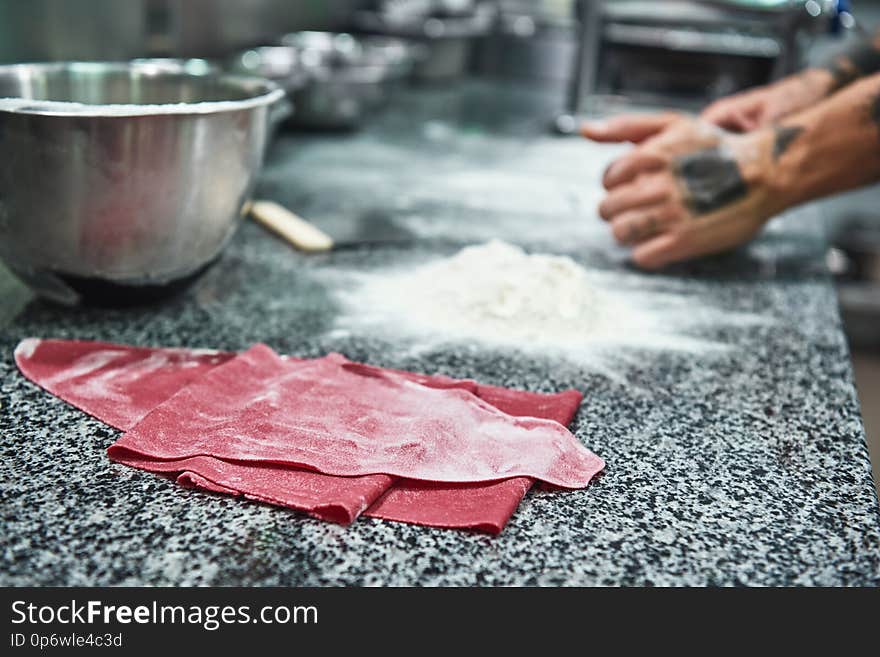 Traditional italian food. Close up photo of colorful dough for homemade pasta lying on the kitchen table. Food concept