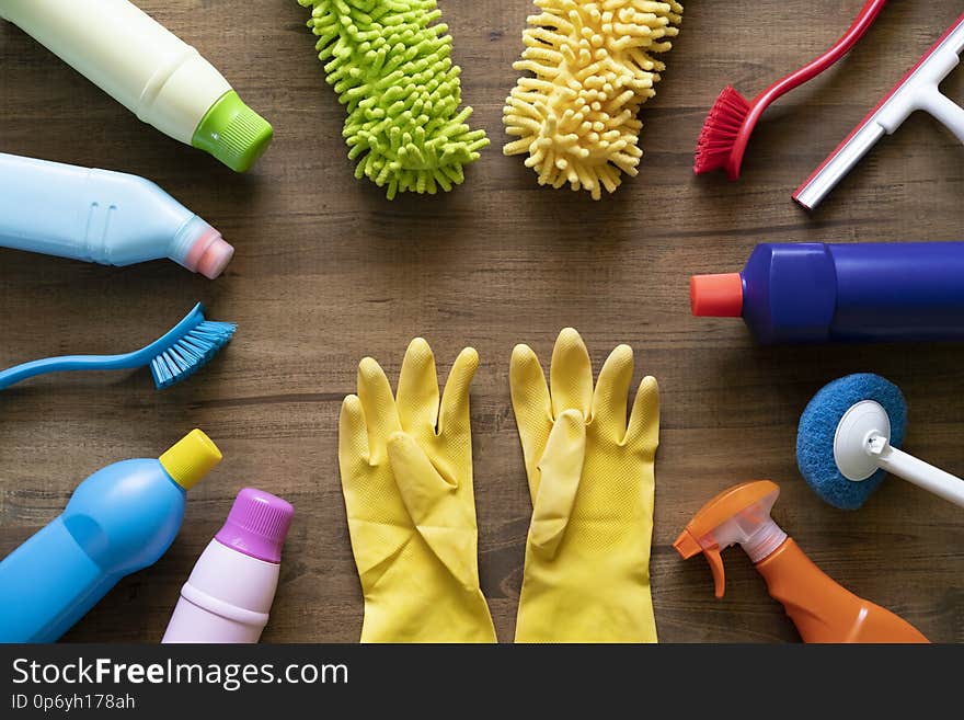 House cleaning product and glove on wood table, top view